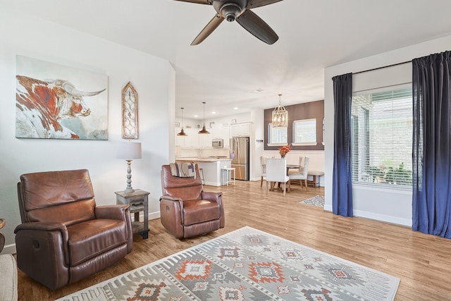 living room with light wood-style flooring, baseboards, a ceiling fan, and recessed lighting