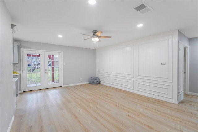 spare room featuring baseboards, french doors, visible vents, and light wood-style floors