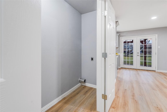 laundry room featuring light wood-type flooring, french doors, electric dryer hookup, and baseboards