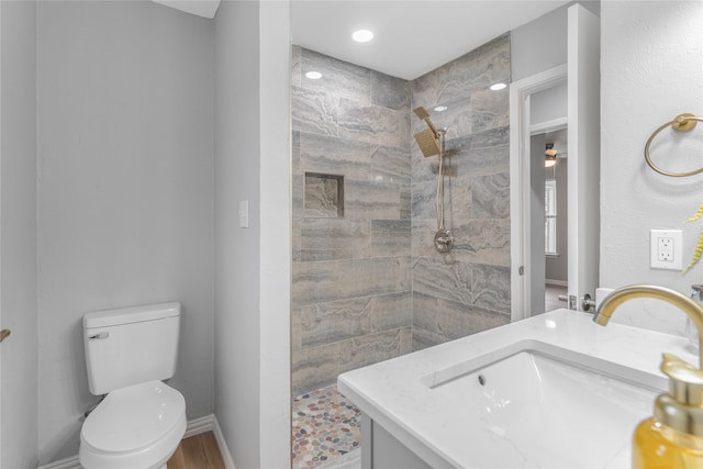 bathroom with baseboards, vanity, toilet, and walk in shower