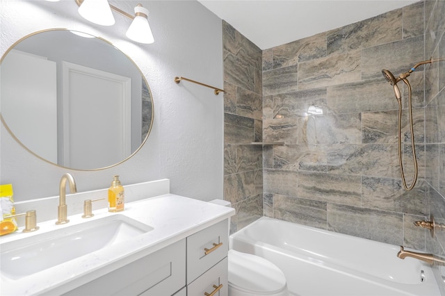 full bath featuring toilet, a textured wall, vanity, and washtub / shower combination