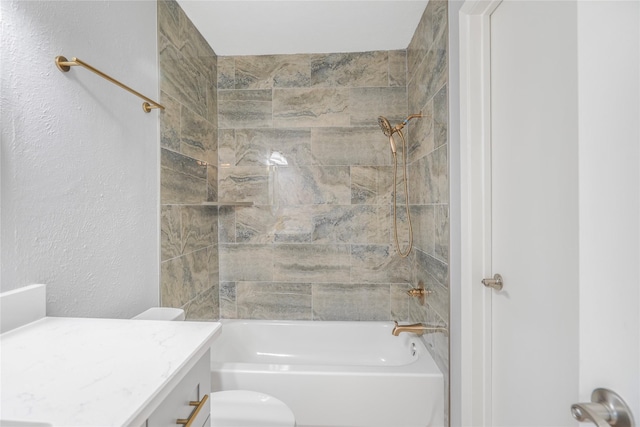 bathroom featuring toilet, a textured wall, bathtub / shower combination, and vanity