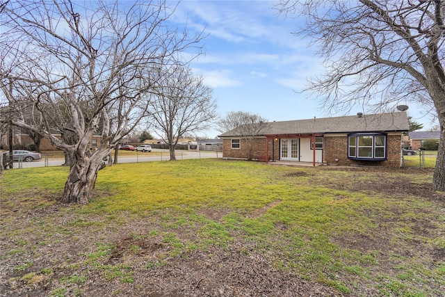 view of yard featuring french doors and fence