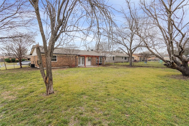 view of yard featuring french doors and fence