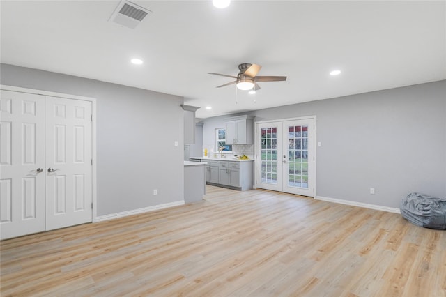 unfurnished living room featuring french doors, visible vents, baseboards, and light wood finished floors