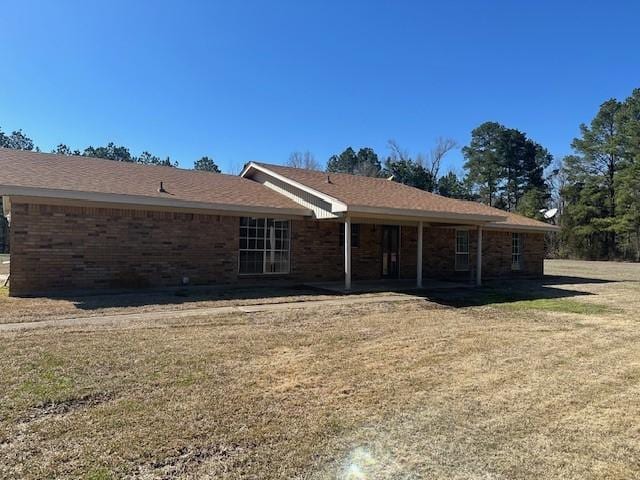 back of property with a patio area, brick siding, and a lawn