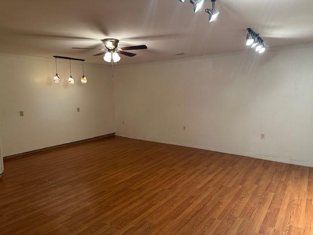 unfurnished room with ornamental molding, ceiling fan, and wood finished floors