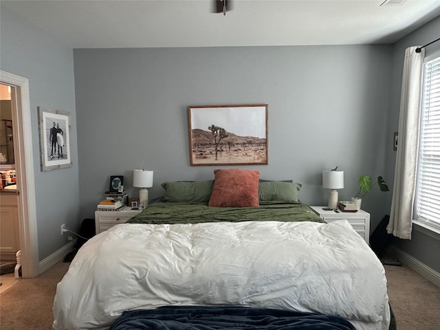 bedroom with baseboards and light colored carpet