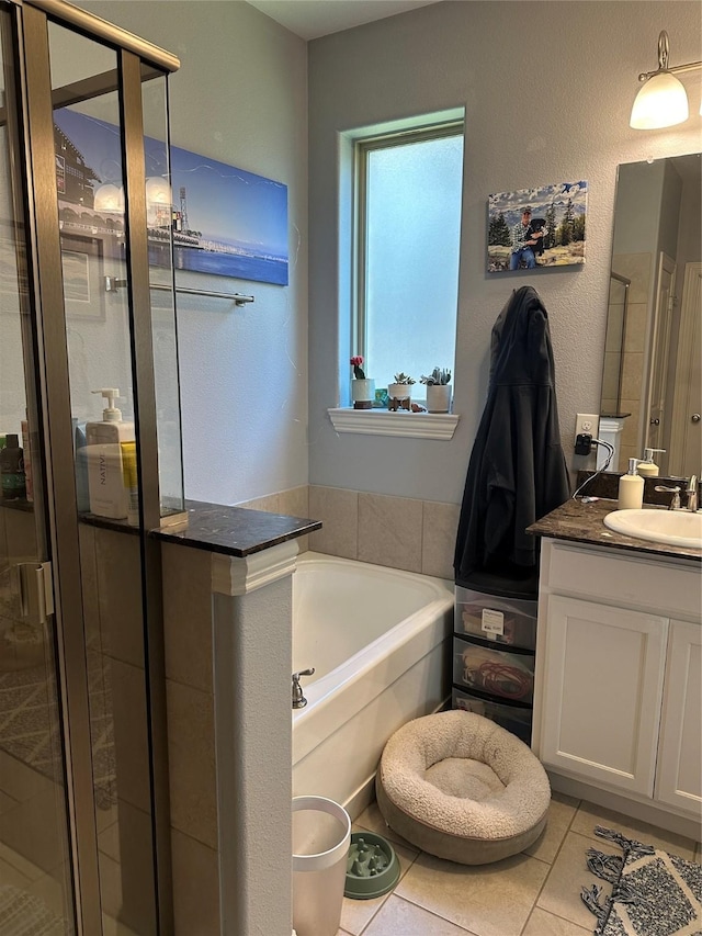 bathroom with a stall shower, vanity, a bath, and tile patterned floors