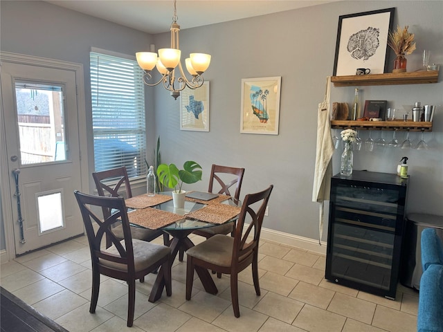 dining space featuring light tile patterned floors, wine cooler, an inviting chandelier, and baseboards