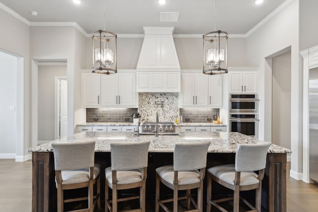 kitchen with ornamental molding, appliances with stainless steel finishes, wood finished floors, and decorative backsplash