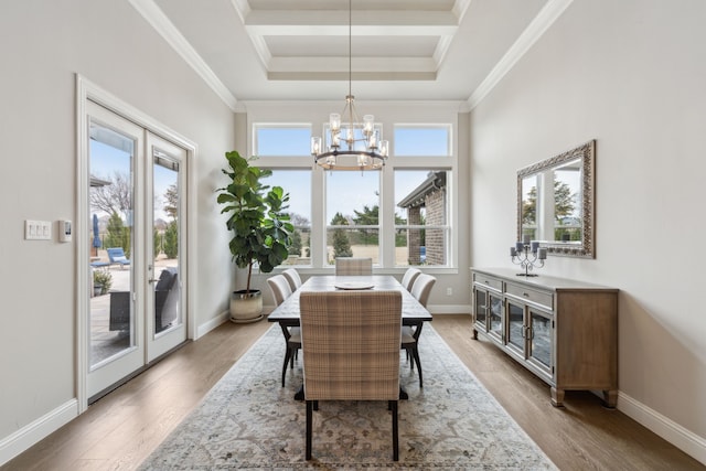 dining room featuring baseboards, ornamental molding, a notable chandelier, and wood finished floors