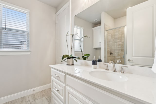 bathroom with visible vents, a shower stall, baseboards, and vanity