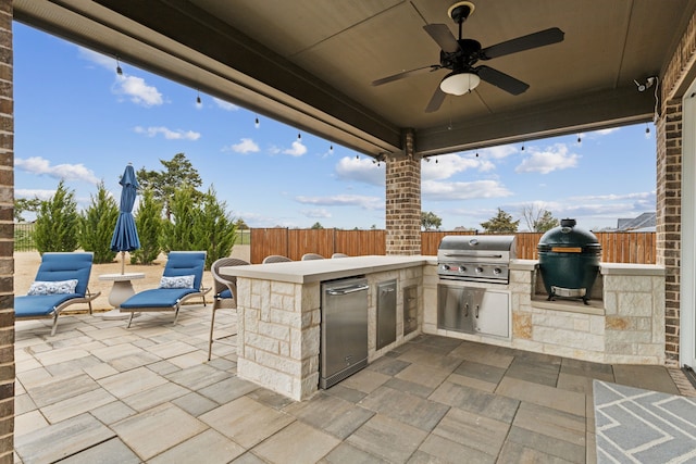 view of patio / terrace featuring ceiling fan, grilling area, an outdoor kitchen, and a fenced backyard