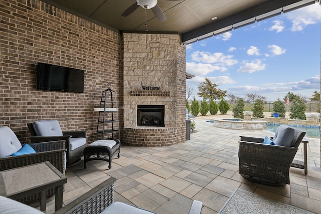 view of patio / terrace with a fenced in pool, an outdoor stone fireplace, a ceiling fan, and an in ground hot tub