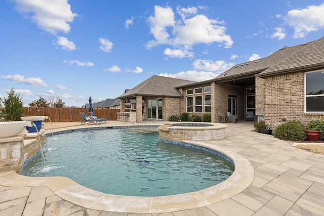 view of swimming pool featuring a patio, fence, and a pool with connected hot tub