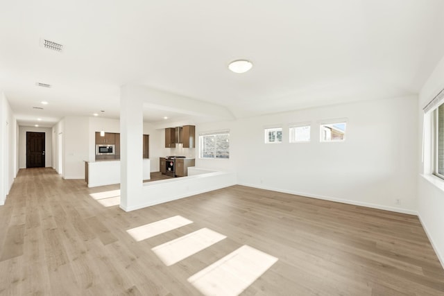 unfurnished living room with light wood-style floors, baseboards, visible vents, and recessed lighting
