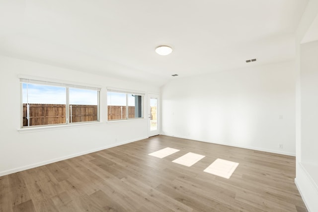 empty room featuring visible vents, baseboards, and light wood-type flooring