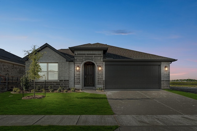 view of front of property featuring brick siding, a front lawn, a garage, and driveway