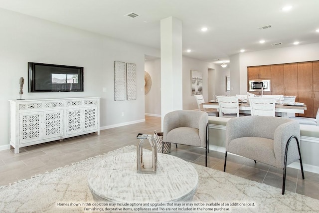 living area featuring baseboards, visible vents, and recessed lighting