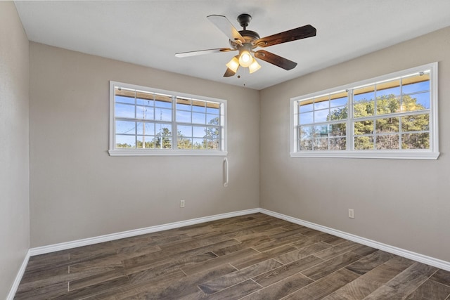 spare room featuring dark wood-type flooring, ceiling fan, and baseboards