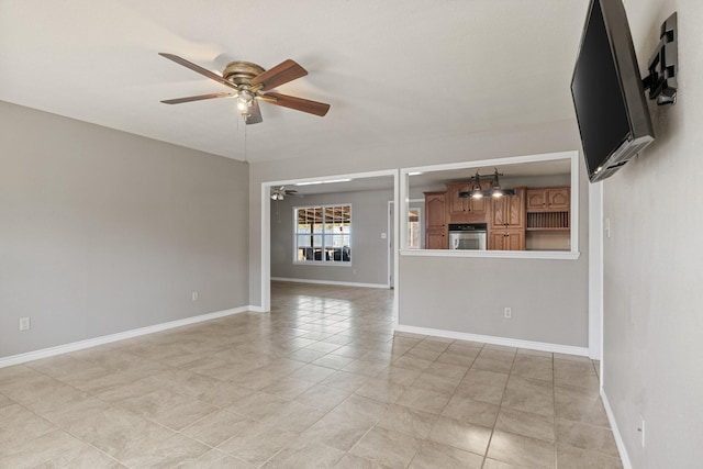 empty room featuring a ceiling fan and baseboards