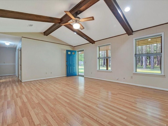 spare room featuring light wood-type flooring, a healthy amount of sunlight, vaulted ceiling with beams, and baseboards