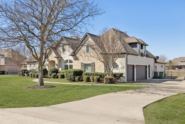 french country style house with concrete driveway, fence, a residential view, stone siding, and a front lawn