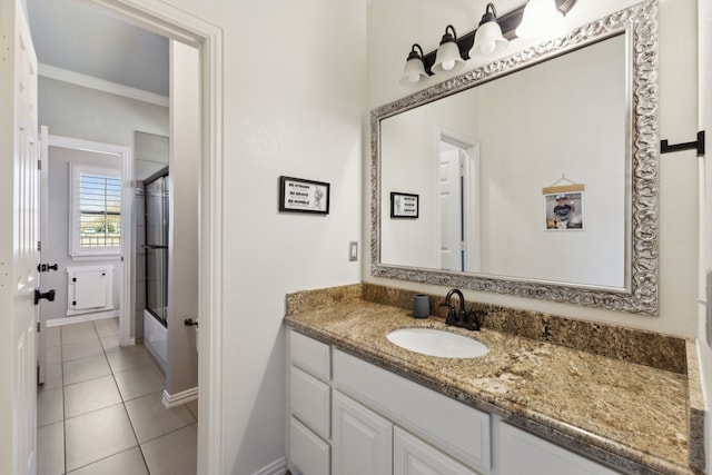 full bath featuring tile patterned flooring, bath / shower combo with glass door, vanity, baseboards, and ornamental molding