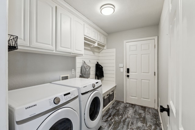 washroom featuring dark wood-style floors, washer and dryer, and cabinet space