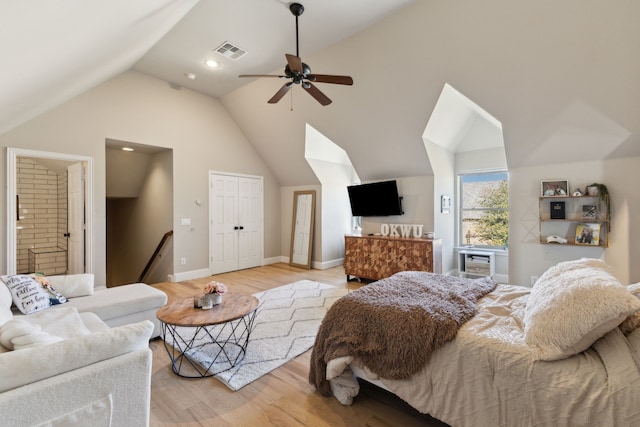 bedroom with visible vents, connected bathroom, high vaulted ceiling, light wood-type flooring, and baseboards