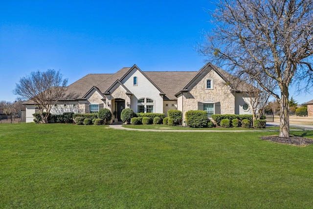 french country inspired facade with stone siding and a front lawn