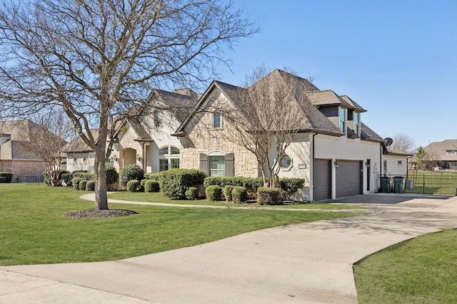 french country inspired facade featuring a front yard, fence, a residential view, stone siding, and driveway