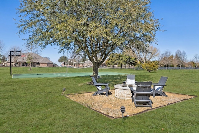 view of yard featuring an outdoor fire pit and community basketball court