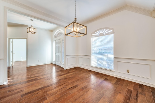 spare room with ornamental molding, hardwood / wood-style flooring, and an inviting chandelier