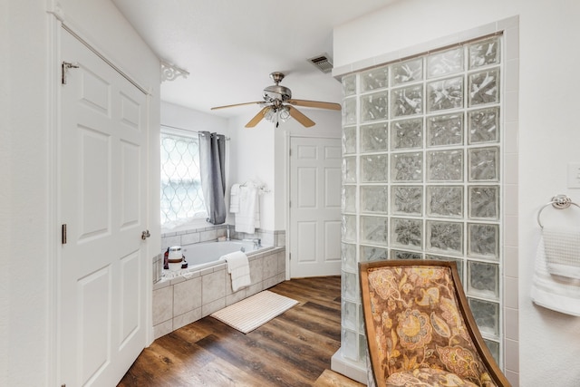 full bathroom featuring visible vents, ceiling fan, wood finished floors, walk in shower, and a bath