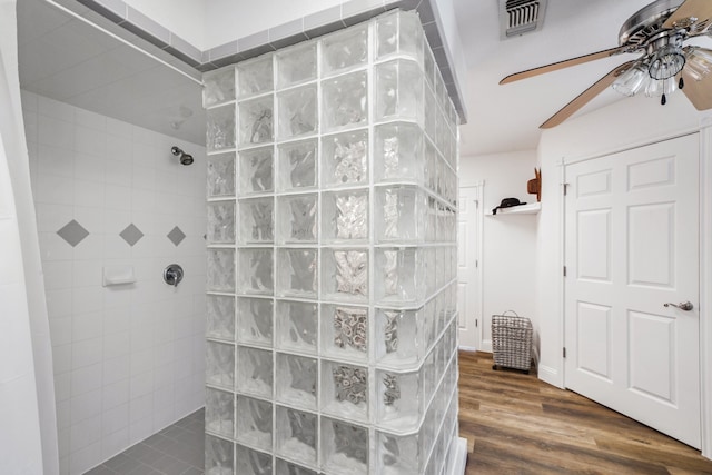 bathroom featuring wood finished floors, visible vents, ceiling fan, and walk in shower