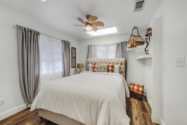 bedroom featuring visible vents, ceiling fan, baseboards, and wood finished floors