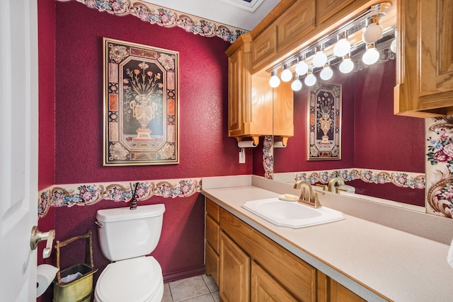 half bathroom with toilet, a textured wall, vanity, and tile patterned floors