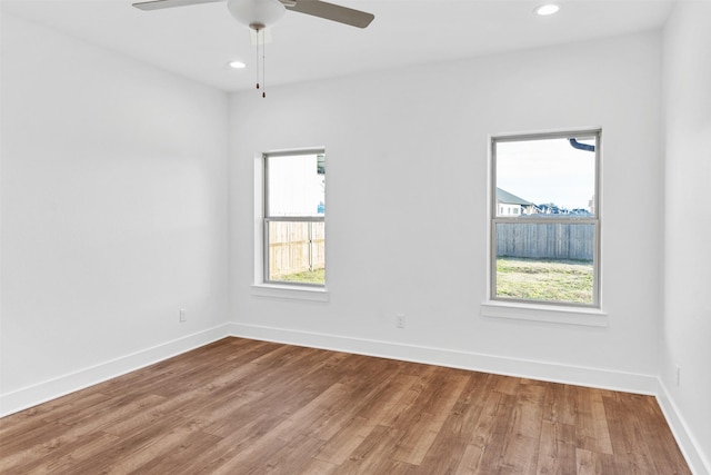 empty room with recessed lighting, baseboards, and wood finished floors