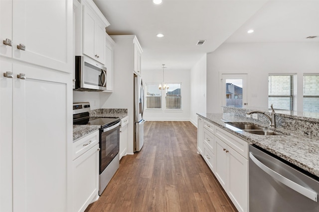 kitchen featuring appliances with stainless steel finishes, dark wood-style flooring, white cabinetry, a sink, and recessed lighting