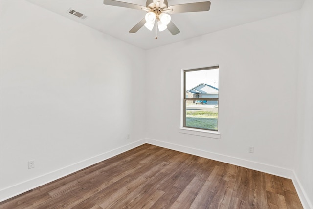 empty room featuring baseboards, visible vents, ceiling fan, and wood finished floors