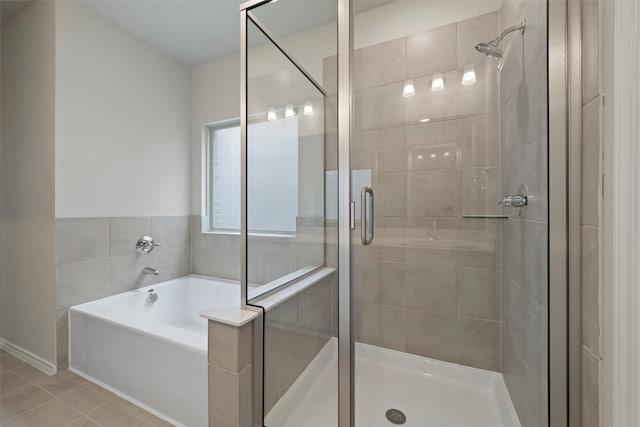 bathroom featuring tile patterned flooring, a shower stall, and a bath