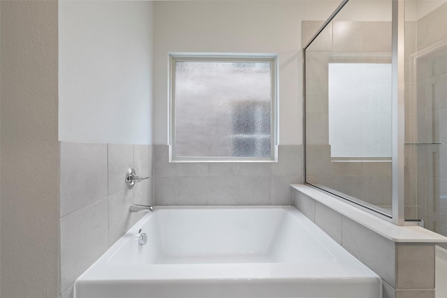 bathroom featuring a healthy amount of sunlight and a garden tub