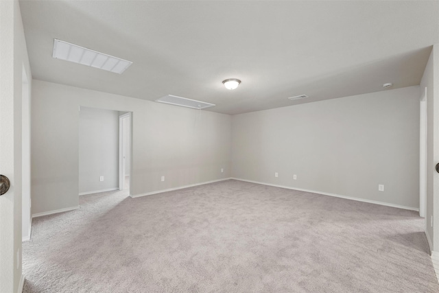 carpeted empty room with visible vents, attic access, and baseboards