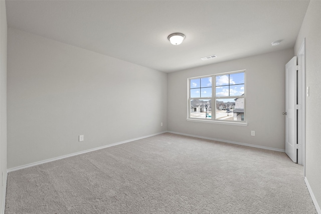 carpeted empty room featuring baseboards and visible vents