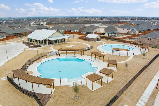 community pool featuring fence and a residential view