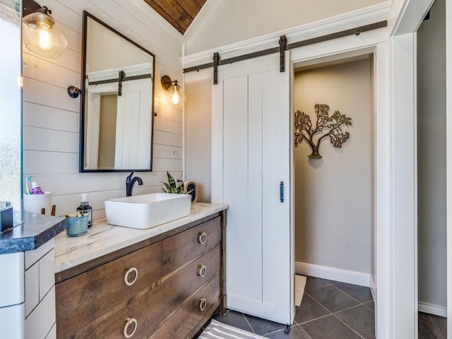 bathroom featuring lofted ceiling, tile patterned flooring, baseboards, and vanity