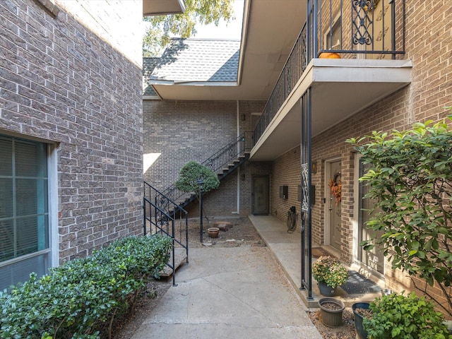 property entrance featuring a patio and brick siding