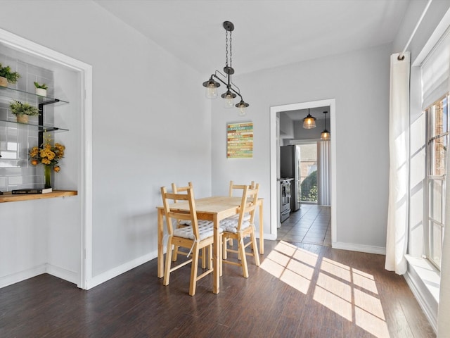 dining room with dark wood-style flooring and baseboards